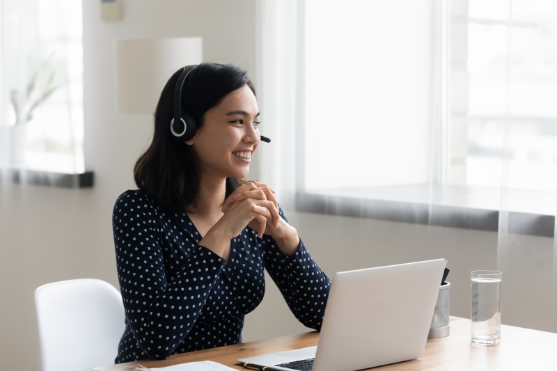 Woman in front of computer talking on headset